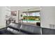 Living room featuring modern black leather furniture and sliders opening to a view of the pool and lake at 11613 Sunshine Pond Rd, Tampa, FL 33635