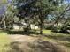 A spacious front yard features mature trees and lush greenery, enhancing curb appeal at 12206 N 53Rd St, Temple Terrace, FL 33617