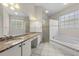 Bathroom featuring double sinks, granite counters, a soaking tub, and a glass-enclosed shower at 12209 Glencliff Cir, Tampa, FL 33626