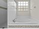 Bright bathtub with tile surround and window in bathroom at 12209 Glencliff Cir, Tampa, FL 33626
