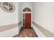 Inviting entryway with a red front door, brick flooring, and elegant architectural details at 12209 Glencliff Cir, Tampa, FL 33626
