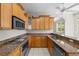 Bright kitchen with granite countertops, stainless appliances, and light wood cabinets at 12209 Glencliff Cir, Tampa, FL 33626