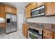 Well-equipped kitchen with stainless steel appliances, granite counters, and wooden cabinetry at 12209 Glencliff Cir, Tampa, FL 33626