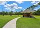 Scenic view of a park pavilion with picnic tables surrounded by lush green grass and trees at 12209 Glencliff Cir, Tampa, FL 33626
