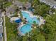 Stunning aerial view of a large community pool with lounge chairs and a bridge surrounded by lush trees and landscaping at 12209 Glencliff Cir, Tampa, FL 33626