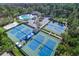 Aerial view of the community's pool, hot tub and tennis courts surrounded by mature Florida trees at 12335 Glenfield Ave, Tampa, FL 33626