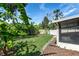Lush backyard with banana trees bordering the white vinyl fence and a view of the screened in lanai at 12335 Glenfield Ave, Tampa, FL 33626