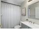 Bathroom with grey vanity and brushed nickel faucet, plus a shower behind a white curtain at 12335 Glenfield Ave, Tampa, FL 33626