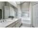 Bathroom with double sinks, large mirror, garden tub under a window, and separate door to toilet and shower at 12335 Glenfield Ave, Tampa, FL 33626