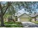 Charming single-Gathering home featuring a well-manicured lawn and mature trees providing ample shade at 12335 Glenfield Ave, Tampa, FL 33626
