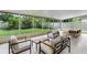 Screened-in porch with comfortable seating, offering a relaxing outdoor space with views of the backyard at 12335 Glenfield Ave, Tampa, FL 33626
