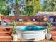 Stock tank pool surrounded by a wooden deck, bench seating, and tropical landscaping in the backyard at 1243 55Th N Ave, St Petersburg, FL 33703