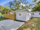 Exterior side view of the home with a concrete patio, fenced yard, and lush green landscaping at 1243 55Th N Ave, St Petersburg, FL 33703