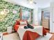 Comfortable bedroom with a tropical leaf accent wall, a ceiling fan, and wood floors at 1243 55Th N Ave, St Petersburg, FL 33703