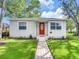 Well-maintained home featuring a brick walkway leading to a red front door, and tidy landscaping at 1243 55Th N Ave, St Petersburg, FL 33703