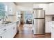 Bright kitchen featuring stainless steel appliances, white cabinetry, and view to the living room at 1243 55Th N Ave, St Petersburg, FL 33703