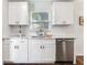 Updated kitchen featuring stainless steel dishwasher, white cabinetry, and marble countertops at 1243 55Th N Ave, St Petersburg, FL 33703