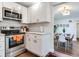 Modern kitchen featuring stainless steel appliances, white cabinets, tile backsplash, and dining room view at 1243 55Th N Ave, St Petersburg, FL 33703