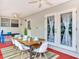 Covered patio with dining table, ceiling fans, and access to the house through double doors at 1243 55Th N Ave, St Petersburg, FL 33703