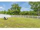 A spacious, fenced backyard featuring green grass and a serene pond view at 12624 White Bluff Rd, Hudson, FL 34669