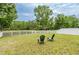 Large backyard with a view of a scenic pond behind a white picket fence, great for outdoor relaxation at 12624 White Bluff Rd, Hudson, FL 34669