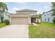 Two-story home featuring a two-car garage and inviting entryway with mature landscaping at 12624 White Bluff Rd, Hudson, FL 34669