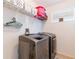 Efficient laundry room with modern washer and dryer, shelving for storage, and a bright window at 12624 White Bluff Rd, Hudson, FL 34669