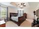 Elegant primary bedroom with tray ceiling, a ceiling fan and ample natural light from the large windows at 12624 White Bluff Rd, Hudson, FL 34669