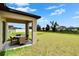 Covered patio with outdoor seating overlooks expansive backyard and green space at 13187 Palmerston Rd, Riverview, FL 33579