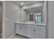Stylish bathroom boasts double sinks, white cabinets, and a large mirror at 13187 Palmerston Rd, Riverview, FL 33579