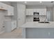Modern kitchen featuring white cabinets, quartz countertops, stainless steel appliances, and an island at 13187 Palmerston Rd, Riverview, FL 33579