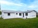 Rear exterior of home with gray roof, clean white paint, and nice lawn at 1415 Yale Dr, Holiday, FL 34691