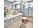 Well-lit bathroom with a vanity, tile, and a shower with glass doors at 1415 Yale Dr, Holiday, FL 34691