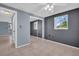 Bedroom showcasing mirrored closet doors, a window, and neutral tile flooring at 1415 Yale Dr, Holiday, FL 34691