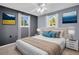 Cozy bedroom featuring two windows, neutral walls, ceiling fan, and comfortable bed with decorative pillows and modern wall art at 1415 Yale Dr, Holiday, FL 34691