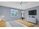 Well-lit bedroom with a large window, modern dresser, and mounted TV, blending comfort and functionality for relaxation at 1415 Yale Dr, Holiday, FL 34691