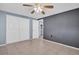 Neutral bedroom featuring a ceiling fan, neutral tile floors, and double closets at 1415 Yale Dr, Holiday, FL 34691