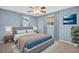 Cozy bedroom with calming blue walls, ceiling fan, and large windows for natural light at 1415 Yale Dr, Holiday, FL 34691