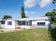 Inviting home featuring a screened-in porch and well-manicured lawn, creating a welcoming curb appeal at 1415 Yale Dr, Holiday, FL 34691