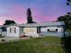 Charming home displaying a freshly manicured lawn with an idyllic twilight sky at 1415 Yale Dr, Holiday, FL 34691