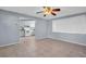 Bright living room with tile floors and a kitchen view, offering a modern ceiling fan and window with natural light at 1415 Yale Dr, Holiday, FL 34691