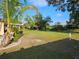 Large backyard featuring green grass, mature trees, and partial view of home at 1510 Flamingo Ln, Sun City Center, FL 33573