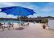 Outdoor pool area with a blue umbrella and many chairs and tables at 1510 Flamingo Ln, Sun City Center, FL 33573