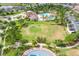 Community aerial view featuring a vast green space, clubhouse, pool, and pickleball courts at 15403 Wicked Strong St, Sun City Center, FL 33573