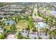 Expansive aerial view showcasing a community with a pool, pickleball court, clubhouse, and green space at 15403 Wicked Strong St, Sun City Center, FL 33573