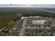 Panoramic aerial perspective of a residential community adjacent to a scenic wooded area and tranquil pond at 15403 Wicked Strong St, Sun City Center, FL 33573