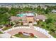 Community clubhouse with pool and amenity center viewed from above, featuring manicured grounds and landscaping at 15403 Wicked Strong St, Sun City Center, FL 33573