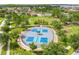 Aerial view of community pickleball courts, pool, clubhouse, and scenic greenery at 15403 Wicked Strong St, Sun City Center, FL 33573