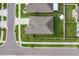 Aerial shot focuses on the roof, green lawn, fenced yard and surrounding neighborhood streets and sidewalks at 15403 Wicked Strong St, Sun City Center, FL 33573