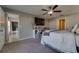 Inviting bedroom with ceiling fan, TV, shelving, and neutral tones offers comfortable and stylish living at 15403 Wicked Strong St, Sun City Center, FL 33573
